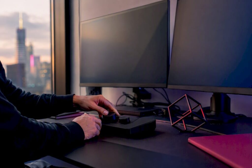 Hands adjusting trading devices in workspace