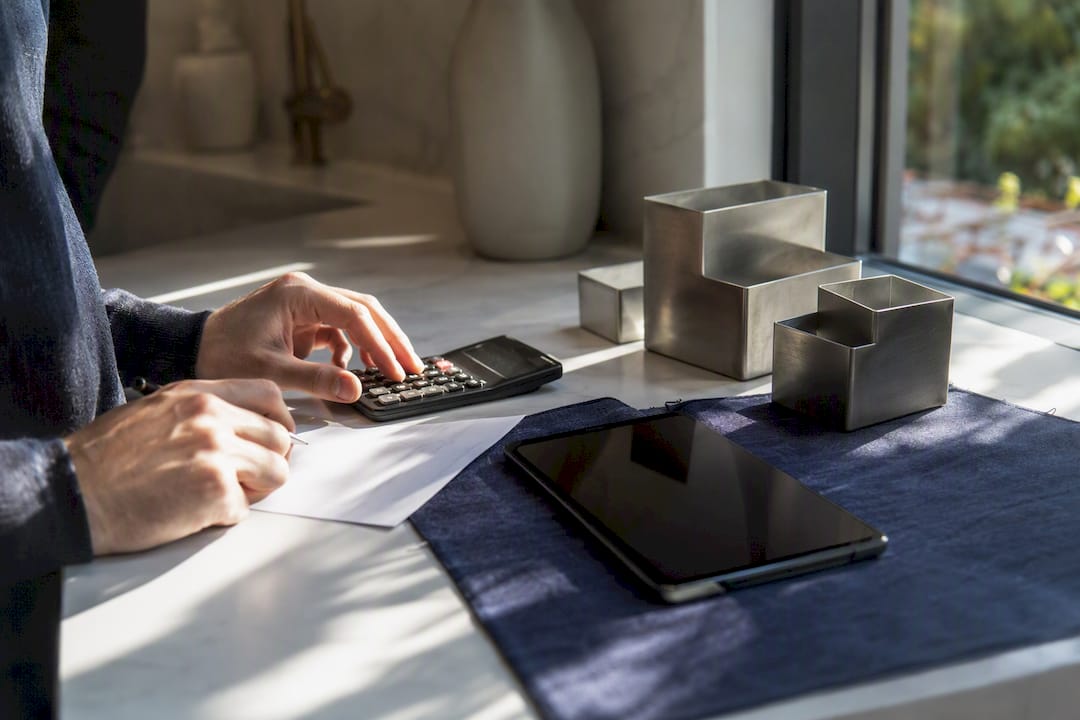 Hands calculating migration funds on desk