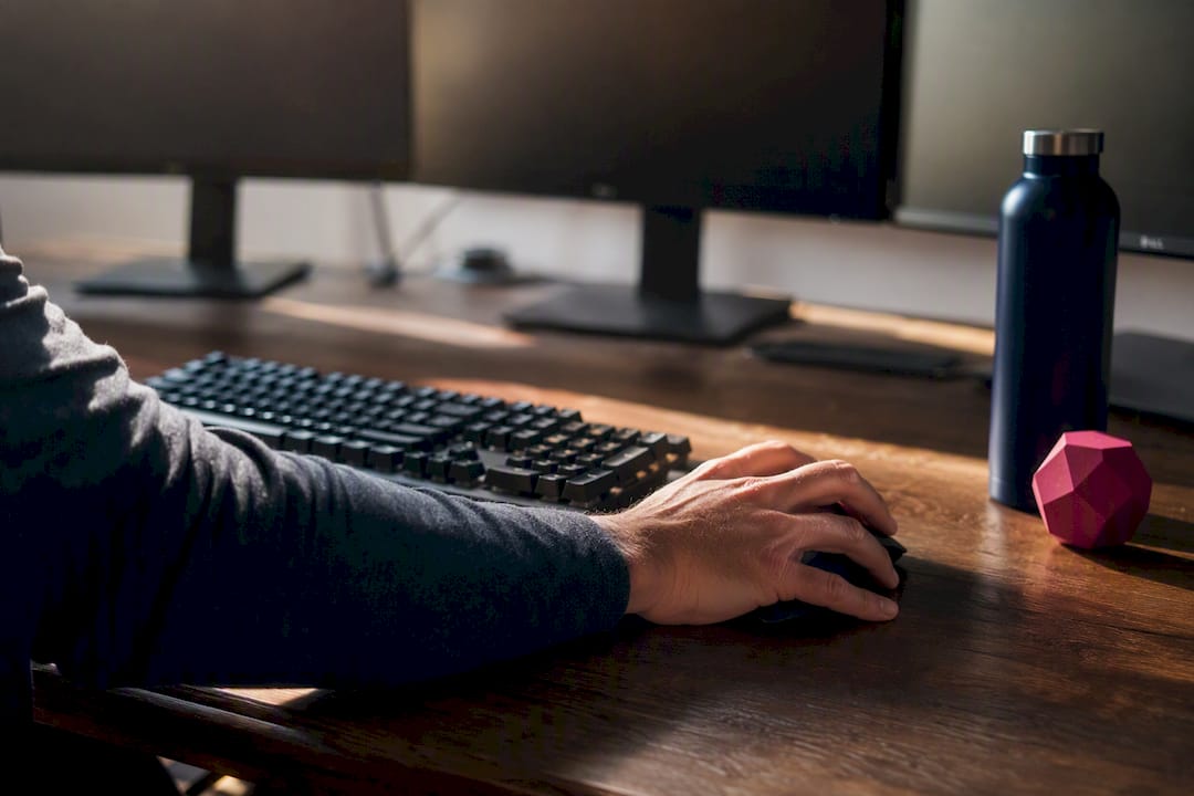 Hand clicking mouse representing fast trade execution